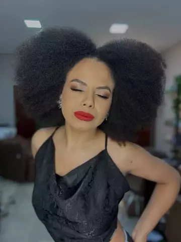 Cliente de cabelo crespo black volumoso e batom vermelho