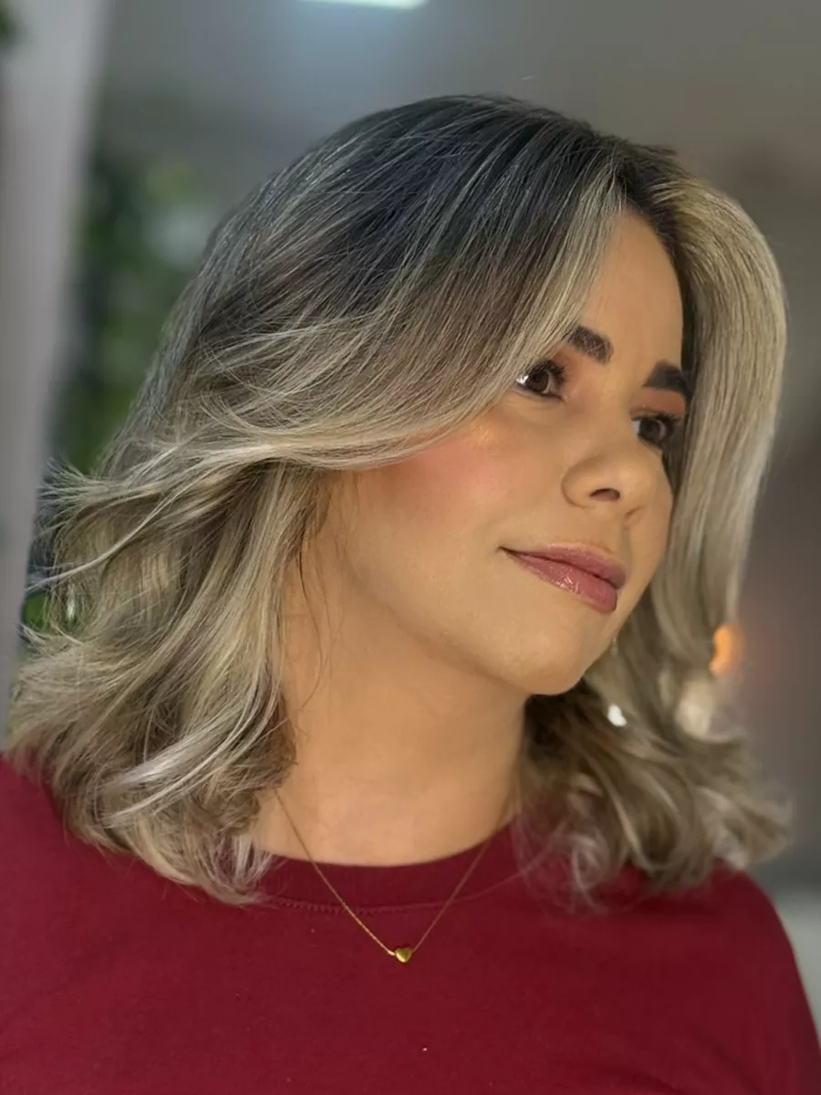 Cliente com corte médio loiro e mechas